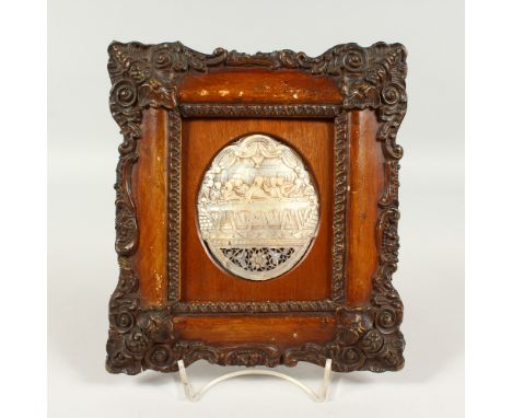 A CARVED MOTHER-OF-PEARL SHELL, depicting The Last Supper, in a decorative frame. 20.5cms high x 18.5cms wide.