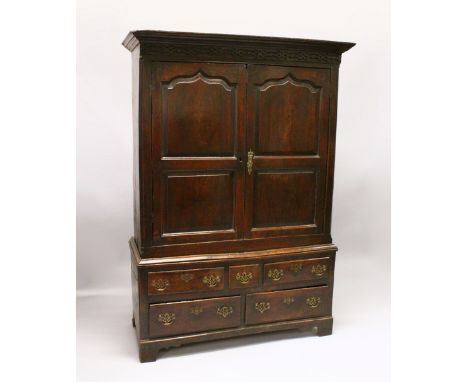 AN 18TH CENTURY OAK BACON CUPBOARD, with a moulded cornice, blind fret decorated frieze above a pair of panelled doors enclos