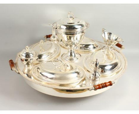 AN IMPRESSIVE LAZY SUSAN STYLE SERVING SET, the large circular stand fitted with four oval dishes and covers with serving spo