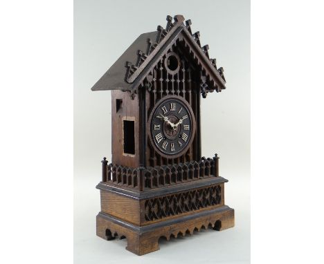 BLACK FOREST MANTEL CUCKOO CLOCK, of 'Chalet' form, with applied Roman numerals and bone hands, stained oak case, 54cms high 