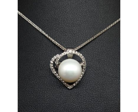 An 18ct open heart pendant and chain set with brilliant cut diamonds and a South Sea cultured pearl in white, the patterned n