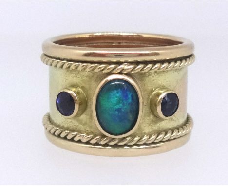 A 9ct gold thumb ring set with two ceylon sapphires and an opal, commissioned and produced by Crazy Pig Designs, approx 13.4g