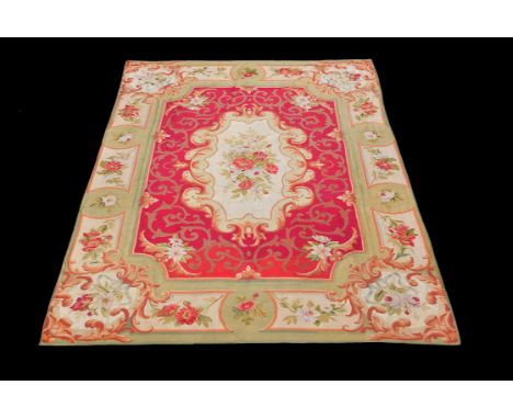 A late 19th/early 20th century Aubusson carpet, with an ivory cartouche filled with roses, on a red ground with floral border