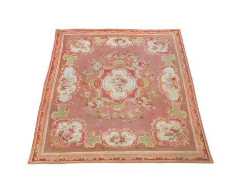 A French needlework carpet, woven in the Aubusson style, late 19th/early 20th century, with coral pink field with central flo