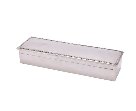 An Edwardian silver long rectangular glove or trinket box by Mappin & Webb, London 1909, plain with a scroll and foliate bord