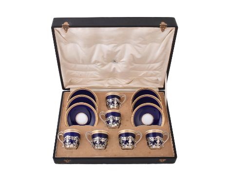 A set of six Edwardian silver coffee cup holders by Mappin & Webb, London 1907, scroll pierced, with inserts and saucers in b