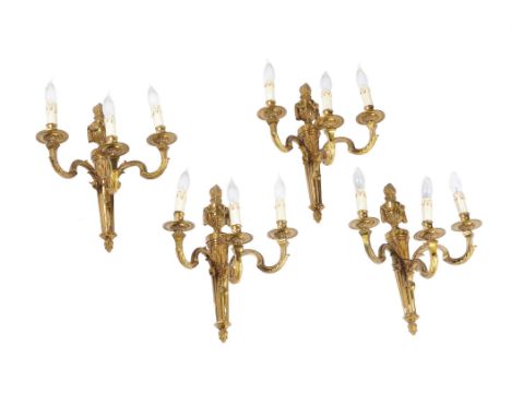 A set of ten gilt metal three light wall appliques in Louis XVI taste, in the manner of designs by Jean-Charles Delafosse, 20