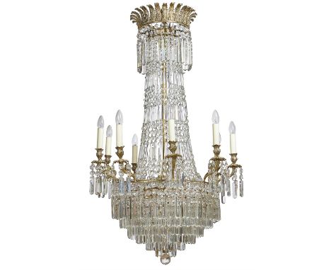 A gilt metal and cut glass nine light chandelier in Regency style, elements late 19th century and later, the outscrolled acan