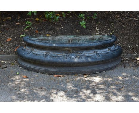 A patinated metal basin or jardiniere, probably 20th century, of demilune form, the bulbous body relief cast with bellflower 