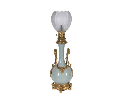 A French celadon glazed porcelain and gilt metal mounted oil lamp, later 19th century, the bottle form celadon glazed body mo