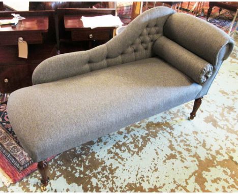 CHAISE LONGUE, of small proportions with a buttoned back, a bolster cushion and grey upholstery on short turned supports with