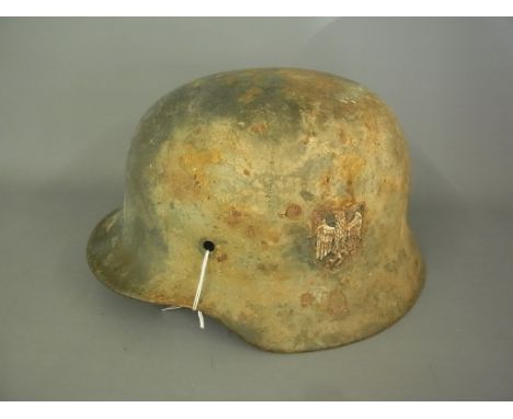 A World War II German helmet Condition report: Some original paint and side transfers, some rust 