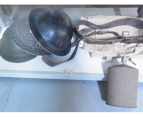 Two British Army World War II steel helmets, an ARP helmet, a water bottle 1943 back pack and a Sam Browne belt 