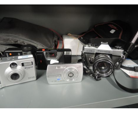 A election of cameras and equipment including Fujica ST301, Polaroid DC3035, Pentax PC35, a Vanguard Mars 1 tripod