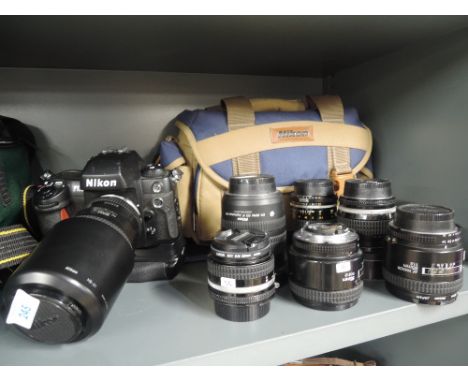 A Nikon F100camera and seven lenses, a 50mm, a 12-24, 85mm, 55mm, 50mm, 62mm and a 75-240mm, with two camera bags