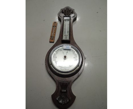 A vintage banjo style barometer and similar thermometer