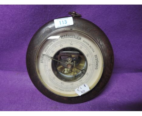 A vintage wall mounted port hole style barometer