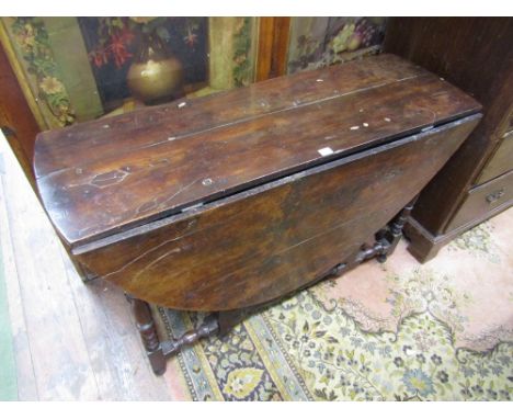 An 18th century gate leg table, unusually in solid yew wood throughout, raised on eight turned supports and rails, enclosing 