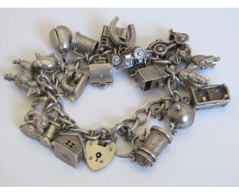 A vintage silver charm bracelet hung with approximately eighteen charms including Sputnik, radiogram, etc, 91g