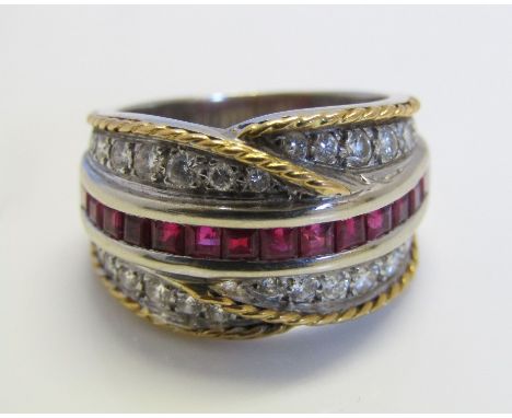 A diamond crossover style ring set with a central line of square cut rubies, with yellow metal rope twist decoration to outer