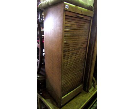 A vintage free standing pedestal filing cabinet with rise and fall tambour roll and shelved interior