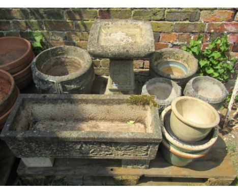 A weathered cast composition stone two section bird bath of square form, with tapered column and flared base with foliate det