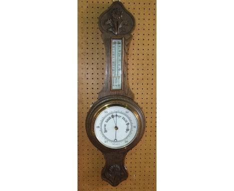 Oak cased barometer thermometer, carved with flower heads