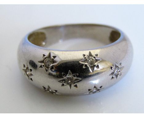 A diamond set ring in white gold with star cut decoration, indistinct marks to outside of shank, size N, 5g