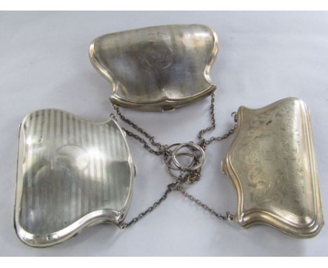 Two similar early 20th century silver purses on chains each with engine turned banded decoration together with a further silv