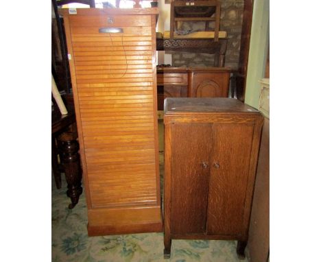 A vintage oak floor standing office filing cabinet with tambour door, together with a low oak side cupboard enclosed by a pai