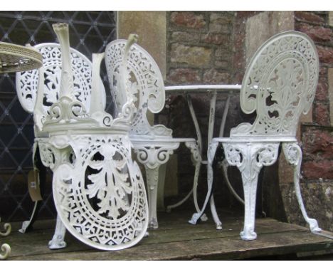 A Victorian style cream painted cast aluminium garden terrace table of circular form with decorative pierced top raised on sw