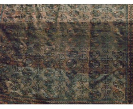 Large Bokhara carpet, decorated with geometric medallions upon a red ground, 360 x 270 cm