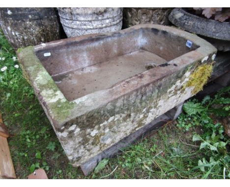 A natural stone trough of rectangular form with single curved end, 68cm long x 44cm wide x 20cm deep approx