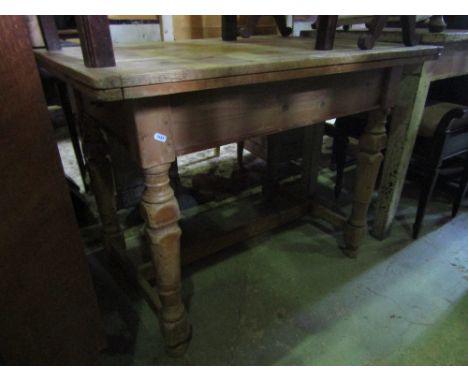 A vintage stripped pine table with rectangular fold over swivel top raised on four partially turned tapered legs united by an
