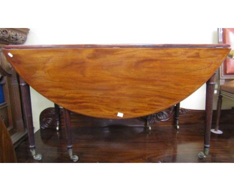 A Georgian mahogany drop leaf dining table with gate leg action, raised on six turned and tapering fluted  supports with bras