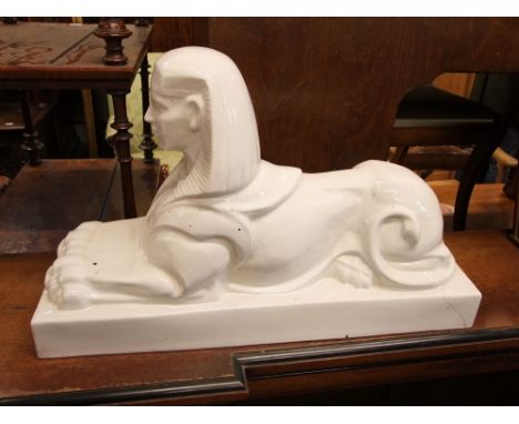 A large early 20th century white glazed ceramic figure of a sphinx, of pseudo Egyptian appearance, stamped Royal Sphinx, 60cm