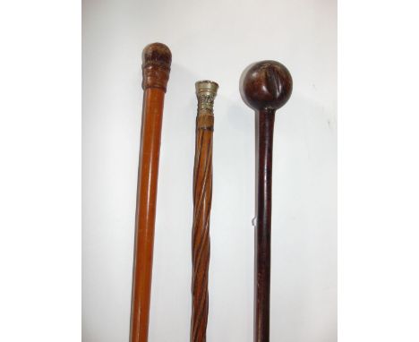 Interesting antique wooden cudgel with spherical ball to one end; together with a further Malacca cane with leather top and p