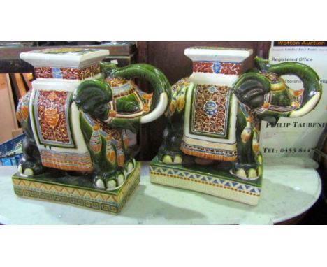 A pair of ceramic elephant garden seats, the creatures in ceremonial dress