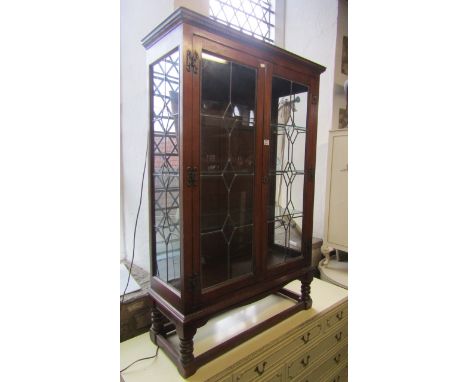An Old Charm oak china display cabinet with leaded light doors, fitted with three plate glass shelves on ring turned supports