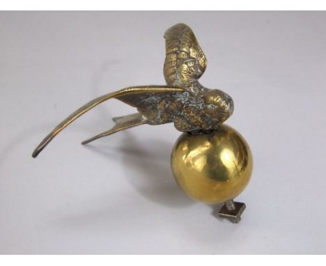 A vintage swift motor car bonnet badge in brass, a swift outstretched wings upon a sphere (the factory closed in 1931)