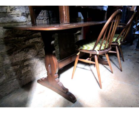 Ercol stained dark elm refectory table on two lyre supports; together with a set of four hoop back dining chairs to include t