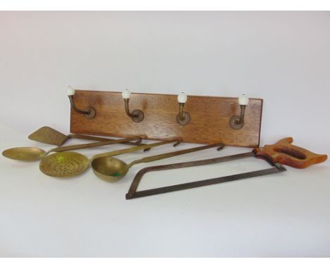 A set of four Victorian gilt metal coat hooks with ceramics knops upon an oak back board, together with a set of four brass c