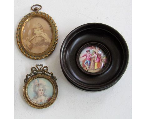 A 19th century portrait miniature of circular form showing a lady in 18th century style costume, 3cm diameter in gilt metal f