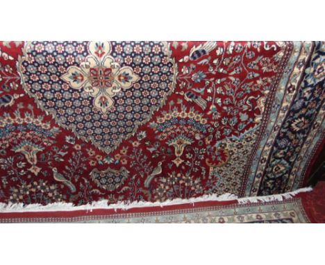 Persian carpet decorated with birds and scrolled foliage upon a red ground, 380 x 270 cm