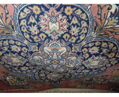 Large wool Eastern carpet centrally decorated with a large blue floral medallion framed by further floral sprays and borders 