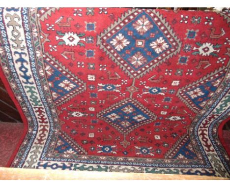 Thick weave Persian carpet with blue and white medallions upon a red ground, 290 x 190cm