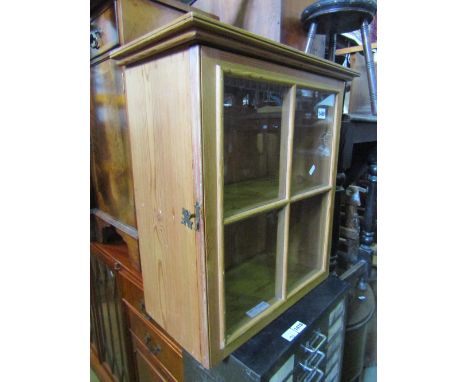 A small stripped pine hanging wall cabinet enclosed by a quarter moulded and glazed panel door, with fixed shelf to interior,