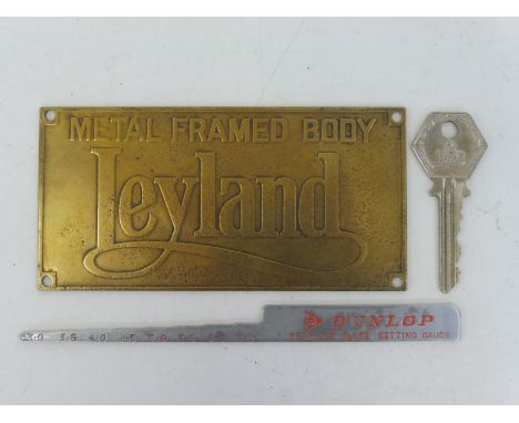 A Leyland rectangular brass plaque, a Dunlop tyre gauge and an RAC key. 