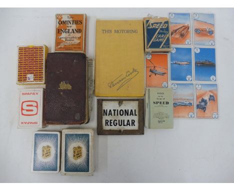 A selection of motoring ephemera including a pack of BP playing cards, an enamel brand indicator etc.