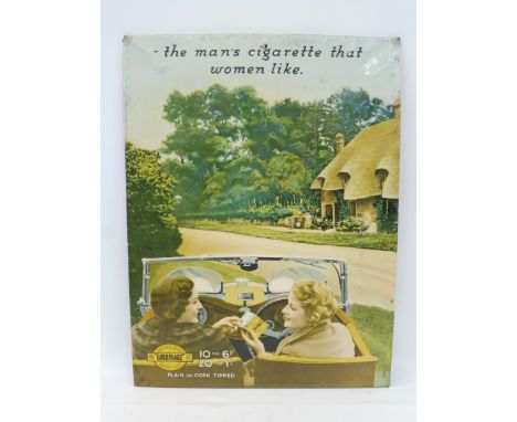 A rare pictorial celluloid covered tin sign depicting two ladies sat in a pre-war motor car, probably a SS1 Jaguar having a W